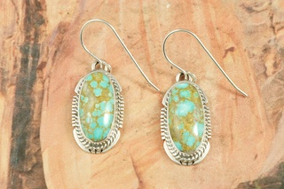 Genuine Number 8 Mine Turquoise Stones set in Sterling Silver French Wire Earrings. The Number 8 mine is located in Eureka County Nevada. Since 1976 there has been no Number 8 Turquoise mined. There is however, an existing stock pile that Mr. Dowell Ward, the last owner of the Number 8 mine, had stocked away for later sorting. The Turquoise is a collector's item--because once the reserve is gone there will be no more material released onto the market. The Gold Mining Company owns the claim to the Number 8 mine and it has been swallowed up by the gold mining operations. This is some of the last Number 8 Turquoise to be had and will be a great addition to your collection. Created by Navajo Artist Arkie Nelson. Signed by the artist.